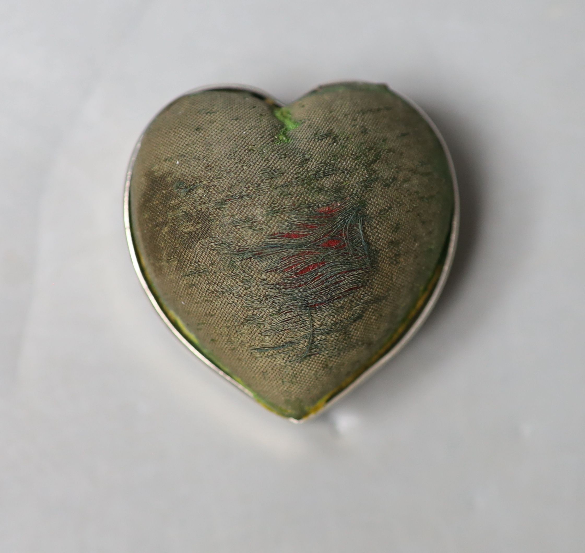 An Edwardian silver mounted heart shaped pin cushion, Birmingham, 1905, 52mm and a filigree white metal card case, 12.1cm.